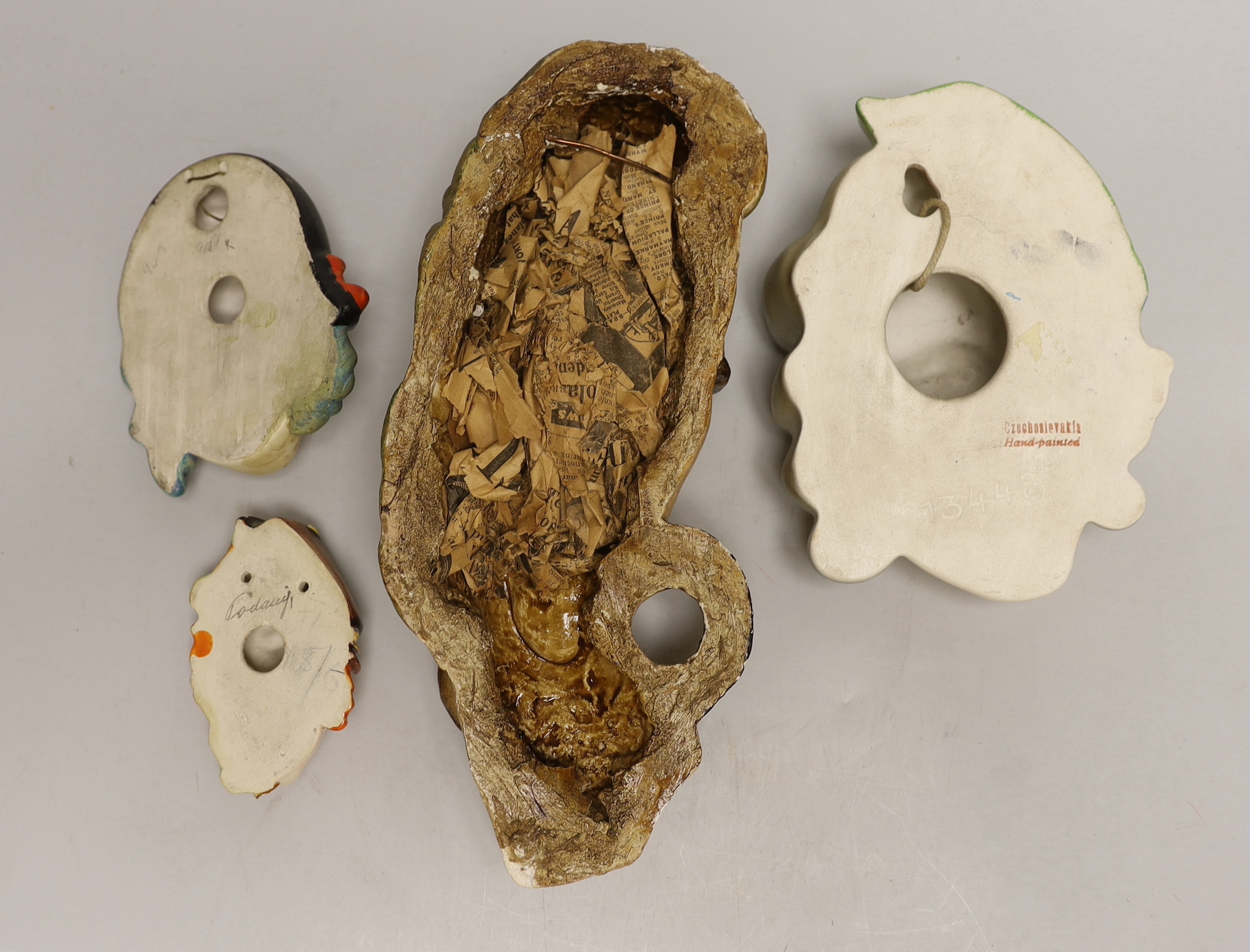 Four various pottery or plaster face masks, largest 28cm